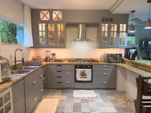 a kitchen with gray cabinets and a stove top oven at Villa Amarela in Itacimirim