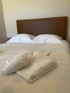a white towel laying on top of a bed at Village House by nature in Karkaloú