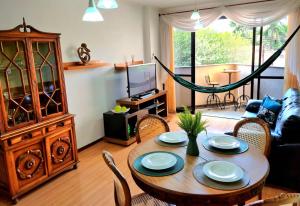a living room with a table and chairs and a couch at Aconchego e estilo, apto 2 quartos, próximo a USP in São Carlos