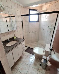 a bathroom with a shower and a toilet and a sink at Aconchego e estilo, apto 2 quartos, próximo a USP in São Carlos +14 photos