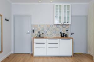 a kitchen with white cabinets and a counter top at Balans Studio Old Town I in Gdańsk