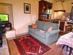 a living room with a couch and a kitchen at Belvilla by OYO Lovely agritourismo near Cortona in Cortona