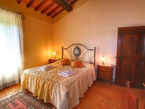 een slaapkamer met een bed en twee nachtkastjes en een raam bij Belvilla by OYO Lovely agritourismo near Cortona in Cortona