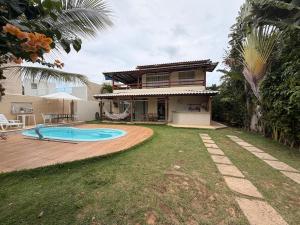 a house with a swimming pool in the yard at Villa Amarela in Itacimirim