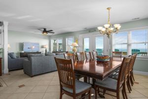 a dining room and living room with a table and chairs at Didjeridu West by Emerald Isle Realty in Emerald Isle
