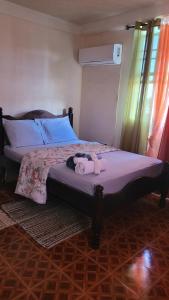 a bedroom with a bed with a stuffed animal on it at Pacific View Apartment in Roseau