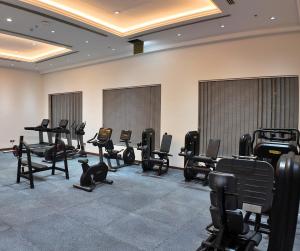 a gym with chairs and treadmills in a room at Anbar International Hotel in Kumaysh
