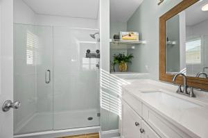 a white bathroom with a shower and a sink at Didjeridu West by Emerald Isle Realty in Emerald Isle +72 photos
