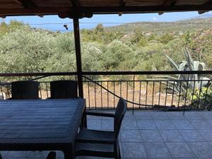 a table and chairs sitting on a porch with a view at Ktima Anna in Astris