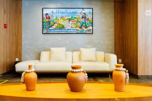 a living room with a couch and two vases on a table at El Aram Beach Boa Viagem in Recife