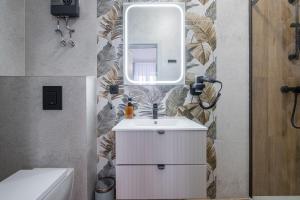a bathroom with a white sink and a mirror at Balans Studio Old Town I in Gdańsk