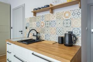 a kitchen with a counter with a stove top oven at Balans Studio Old Town I in Gdańsk +7 photos
