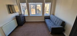a living room with a blue couch and a window at SELF CHECK-IN PENTHOUSE APARTMENT in HALIFAX CENTRE in Halifax