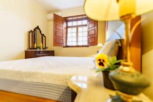 a bedroom with a bed with a table and a window at Casa Fermil do Lago in Veade