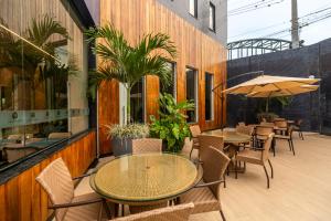 an outdoor patio with tables and chairs and plants at Amazon Park Hotel in Belém
