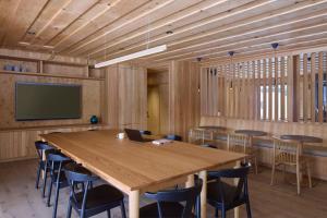 a conference room with a large wooden table and chairs at Balnea Hôtel - Anciennement Beatnik Hôtel in Bromont