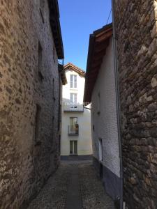 an alley between two buildings with a building in the background at Piccolo gioiello rustico in Losone