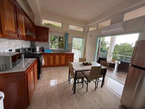 a kitchen with a table and a table and chairs at You 4 Ric Piton Suites in Soufrière