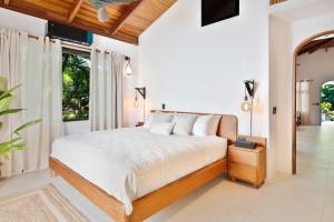 a bedroom with a bed and a large window at Serena Nosara Beach Retreat in Nosara