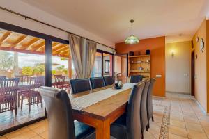 a dining room with a wooden table and chairs at Villa Cora - Traumvilla mit privatem Tennisplatz & beheiztem Pool in Triquivijate