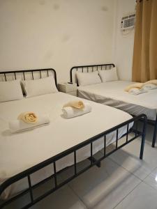 two beds with towels on top of them in a room at Seanna's Inn in San Juan