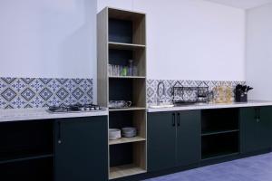 a kitchen with blue cabinets and white counter tops at Beshic Hostel in Tashkent
