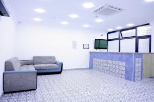 a waiting room with a couch and a tv in it at Beshic Hostel in Tashkent