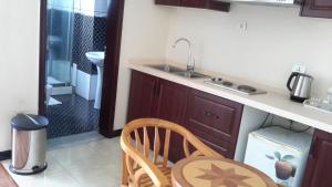 a kitchen with a sink and a table and a bathroom at Impress Hotel in Addis Ababa +38 photos