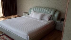 a bed with white sheets and pillows in a bedroom at Impress Hotel in Addis Ababa