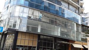 a tall glass building on a city street at Impress Hotel in Addis Ababa