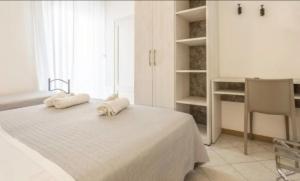 a white bedroom with two towels on a bed at Hotel Villa Lieta in Rimini