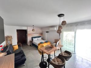 a living room with a bed and a table at Boho Studio Enjoy in Neoi Epivates