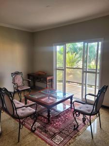 a living room with a coffee table and two chairs at Fênix Plaza Hotel in Aquidauana