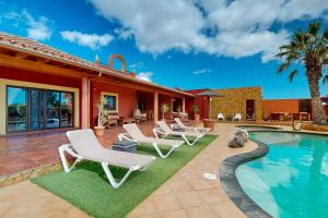 a patio with lounge chairs and a swimming pool at Villa Cora - Traumvilla mit privatem Tennisplatz & beheiztem Pool in Triquivijate