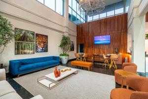 a living room with a blue couch and a tv at Amazon Park Hotel in Belém