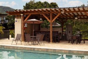 a patio with a table and an umbrella next to a pool at Cabaña Solara in Jardin