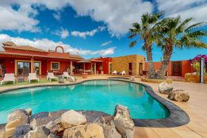 a home with a swimming pool and a house at Villa Cora - Traumvilla mit privatem Tennisplatz & beheiztem Pool in Triquivijate