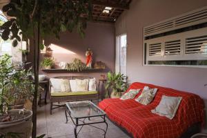 a living room with a red couch and a table at Casa com Varanda, Quintal e Churrasqueira em Bonito PE in Bonito