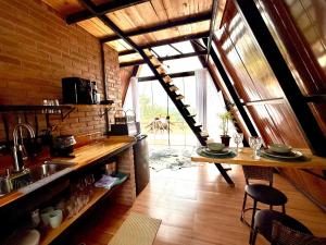 a kitchen with a sink and a table in a room at Cabana da Lua Chalés Vero Verde in Serra Negra
