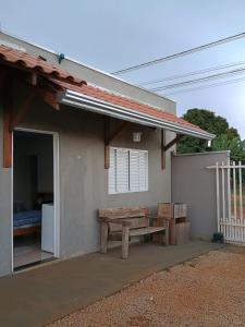 a house with a picnic bench in front of it at Pousada Zero Três - 03 in Chapada dos Guimarães