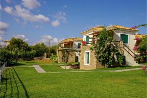 a house with a yard with green grass at Panorama Beach in Chrani