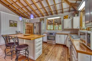 a kitchen with white cabinets and a wooden floor at Apartment by the Caribbean sea in Cahuita
