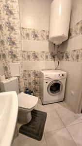 a bathroom with a toilet and a washing machine at Однокімнатні апартаменти в новому ЖК in Vasylʼkiv
