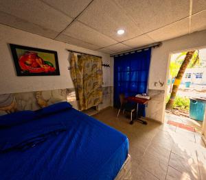 a bedroom with a blue bed and a table at Hostal Bahia Bocachica in Cartagena de Indias +22 photos