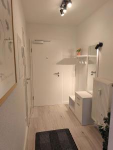 a white room with a hallway with a door and a rug at Ferienwohnung Evelina in Bad Neuenahr-Ahrweiler +9 photos