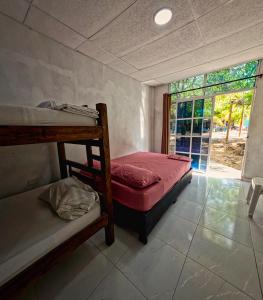 a bedroom with two bunk beds and a window at Hostal Bahia Bocachica in Cartagena de Indias