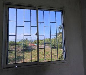 a window with a view of a yard at Hostal Bahia Bocachica in Cartagena de Indias