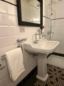 a white bathroom with a sink and a mirror at Dimora di Duen - Villa Storica di Charme in Villa San Giovanni +33 photos