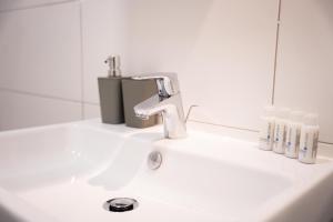 a bathroom sink with a faucet and toothbrushes at Design Apartment - Solingen-Mitte - Balkon - BRIGHT Collection in Solingen