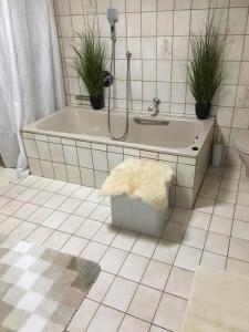 a bathroom with a bath tub with two plants at Ferienwohnung Vechta in Vechta +13 photos